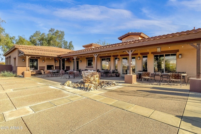 rear view of house with a patio and stucco siding