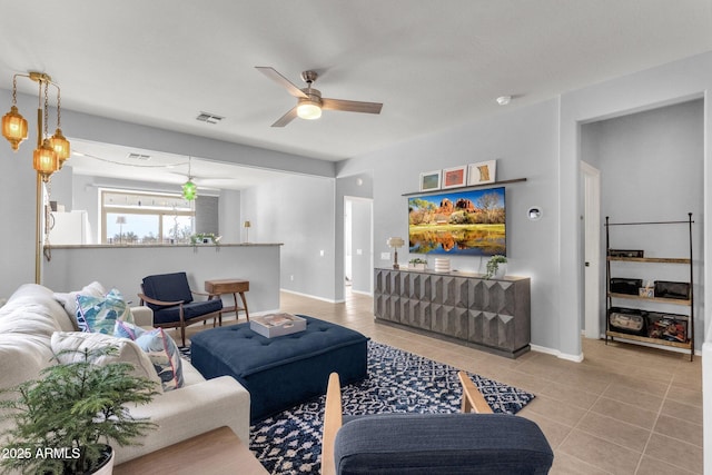 living area featuring light tile patterned floors, baseboards, visible vents, and a ceiling fan