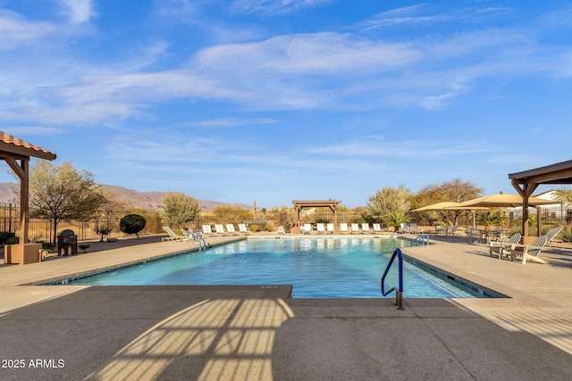 pool featuring fence, a mountain view, and a patio