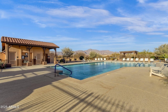 pool with fence, a mountain view, and a patio