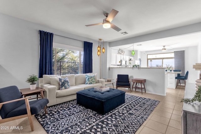 living room featuring a healthy amount of sunlight, light tile patterned floors, ceiling fan, and visible vents