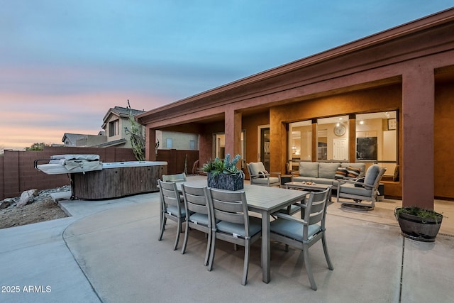 patio terrace at dusk with an outdoor hangout area, outdoor dining area, fence, and a hot tub