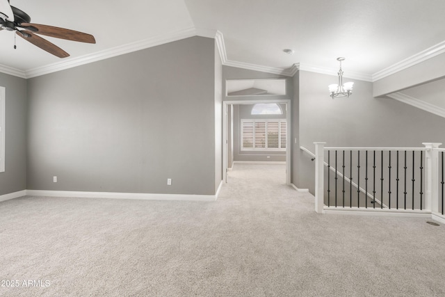 carpeted empty room featuring a chandelier, ornamental molding, baseboards, a ceiling fan, and vaulted ceiling