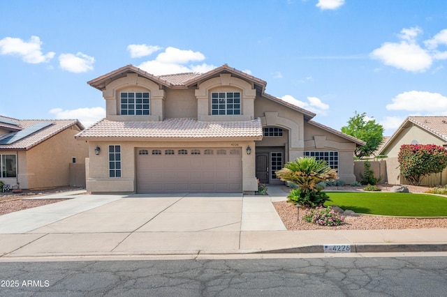 traditional home with stucco siding, a tiled roof, concrete driveway, and a garage