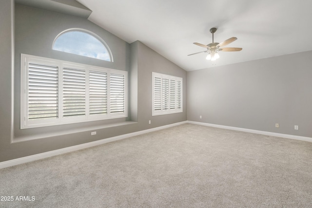 empty room featuring lofted ceiling, carpet flooring, ceiling fan, and baseboards
