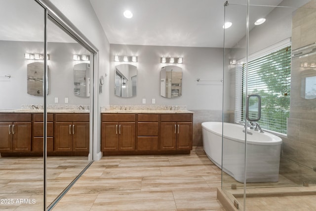 full bathroom featuring a freestanding bath, vanity, and a shower stall