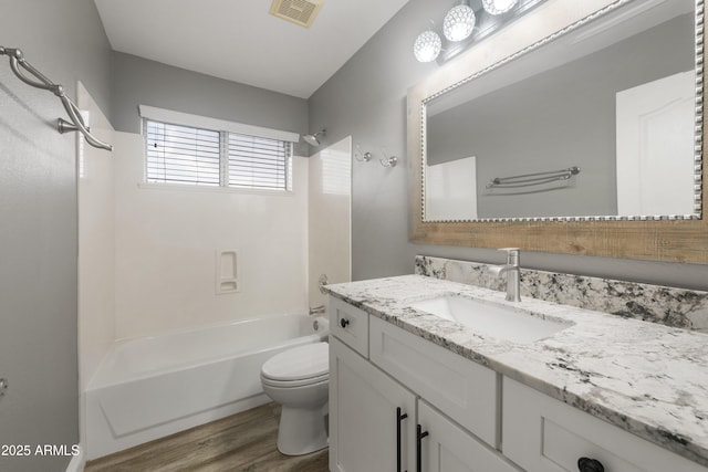 bathroom with  shower combination, wood finished floors, toilet, and vanity