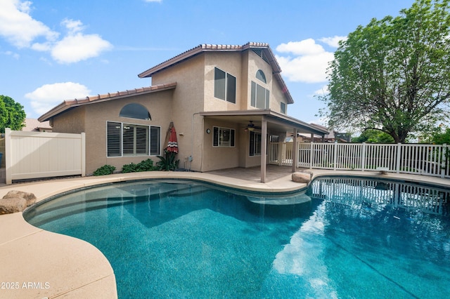 view of swimming pool featuring ceiling fan, fence, and a patio area