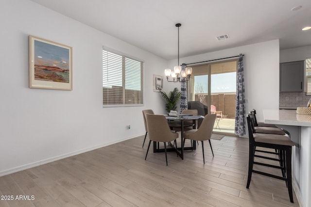 dining space featuring light wood-style floors, visible vents, and plenty of natural light