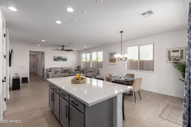 kitchen with light countertops, light wood-type flooring, visible vents, and gray cabinetry