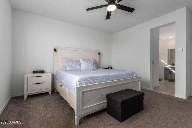 bedroom with ensuite bath, carpet, baseboards, and ceiling fan