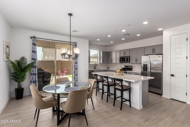 dining room with recessed lighting, visible vents, and light wood-style flooring