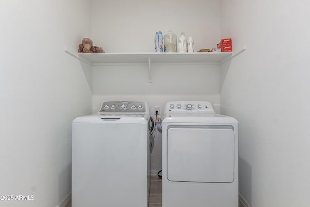 washroom with laundry area, separate washer and dryer, and baseboards