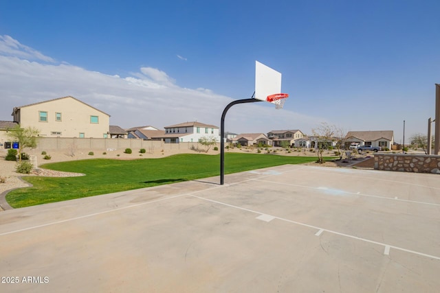 view of basketball court featuring a yard, fence, a residential view, and community basketball court