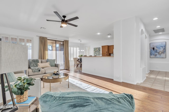 living room featuring ceiling fan and light hardwood / wood-style floors