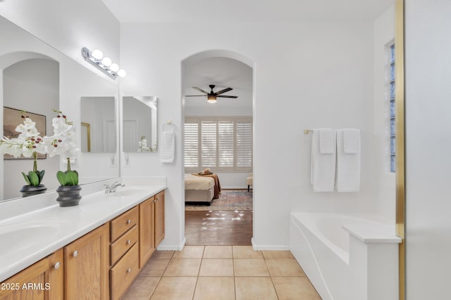 bathroom with ceiling fan, a bath, vanity, and tile patterned floors