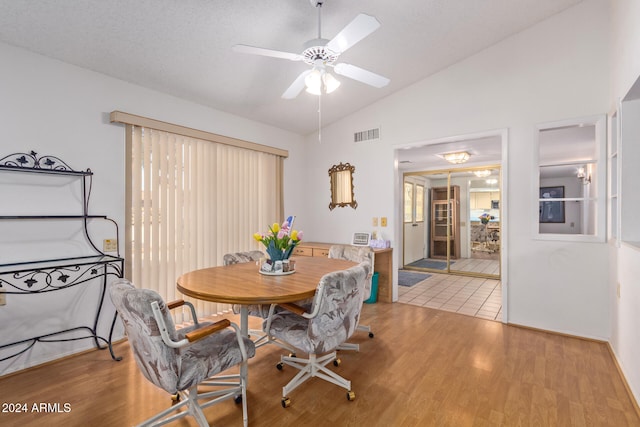 dining area featuring wood-type flooring, a textured ceiling, ceiling fan, and lofted ceiling