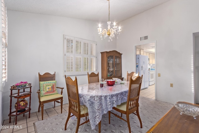 dining room with a textured ceiling, high vaulted ceiling, a notable chandelier, and light tile patterned flooring