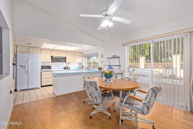 dining space featuring a textured ceiling, ceiling fan, lofted ceiling, and light wood-type flooring