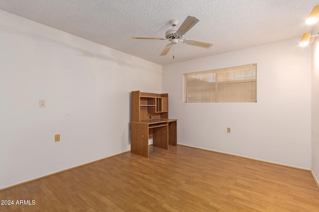 spare room with a textured ceiling, light wood-type flooring, and ceiling fan