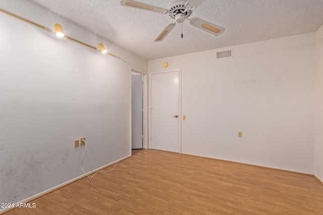 unfurnished room with ceiling fan, a textured ceiling, and light hardwood / wood-style flooring