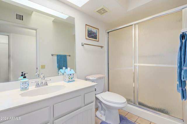 bathroom with tile patterned floors, vanity, an enclosed shower, and toilet