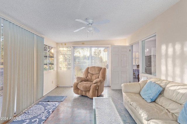 living room featuring a textured ceiling, ceiling fan, and vaulted ceiling