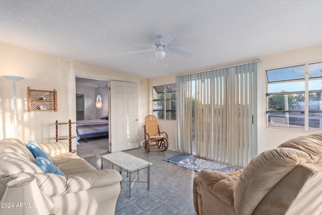 carpeted living room with ceiling fan and a textured ceiling