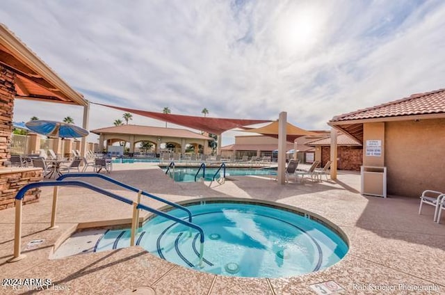 view of swimming pool with a community hot tub and a patio