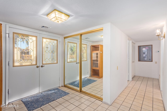 entryway featuring light tile patterned floors and a textured ceiling