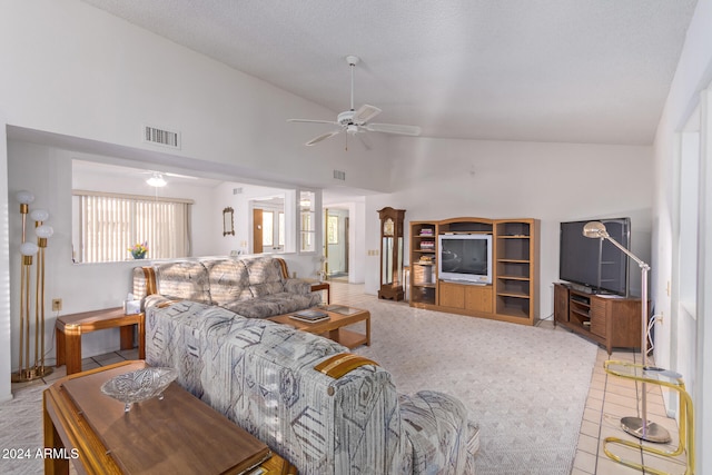 carpeted living room featuring ceiling fan, high vaulted ceiling, and a textured ceiling