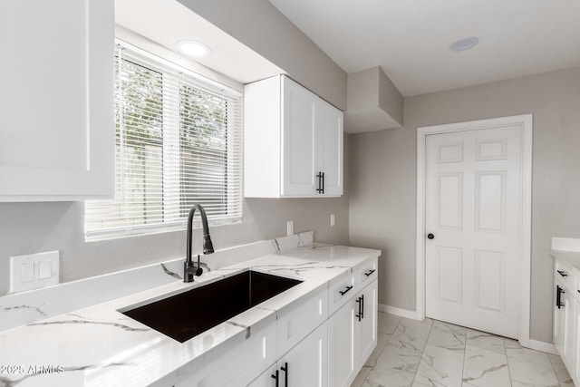 9105 N 13th St, Phoenix, AZ 85020 - kitchen featuring light stone counters, baseboards, a sink, white cabinets, and marble finish floor