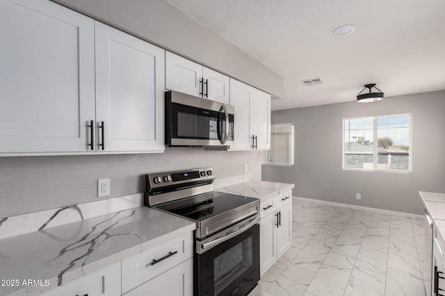 9105 N 13th St, Phoenix, AZ 85020 - kitchen featuring visible vents, marble finish floor, stainless steel appliances, white cabinets, and baseboards