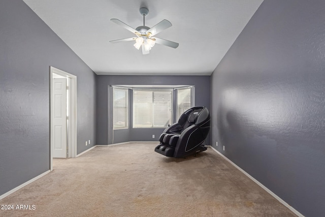 living area with ceiling fan, vaulted ceiling, and light colored carpet