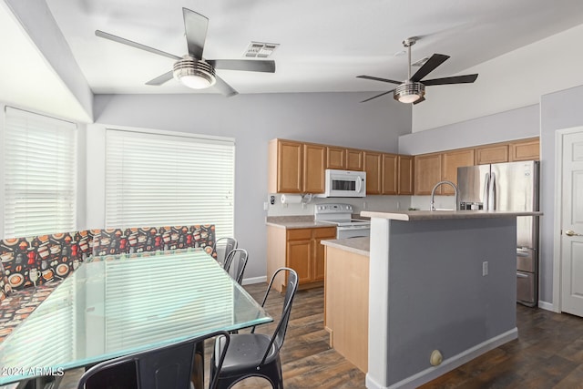 kitchen with white appliances, dark hardwood / wood-style floors, a center island with sink, and vaulted ceiling