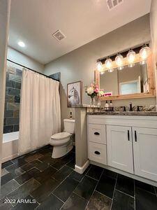 full bathroom featuring shower / bathtub combination with curtain, toilet, tile floors, and vanity