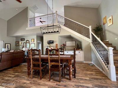 dining room featuring a healthy amount of sunlight, hardwood / wood-style floors, and a towering ceiling