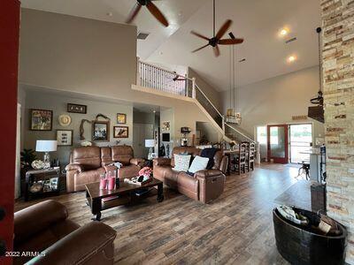 living room with high vaulted ceiling, hardwood / wood-style floors, and ceiling fan