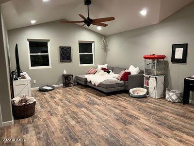 bedroom with wood-type flooring, ceiling fan, and vaulted ceiling