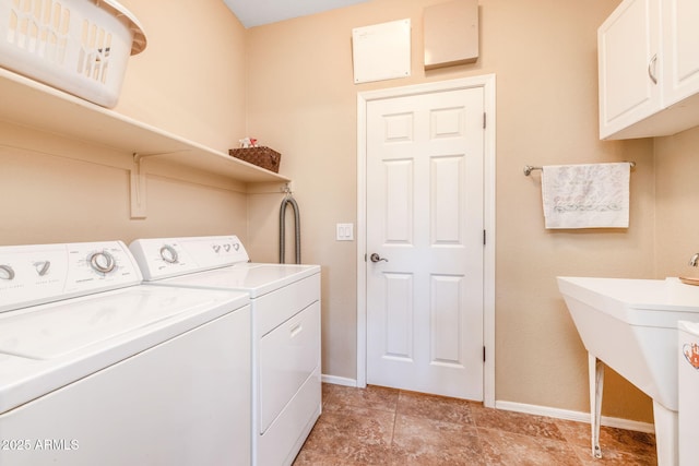 clothes washing area with cabinets and washing machine and clothes dryer