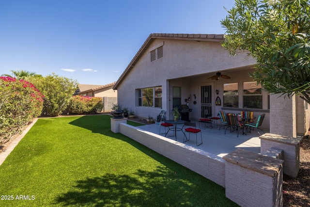 rear view of property featuring a yard, a patio, and ceiling fan