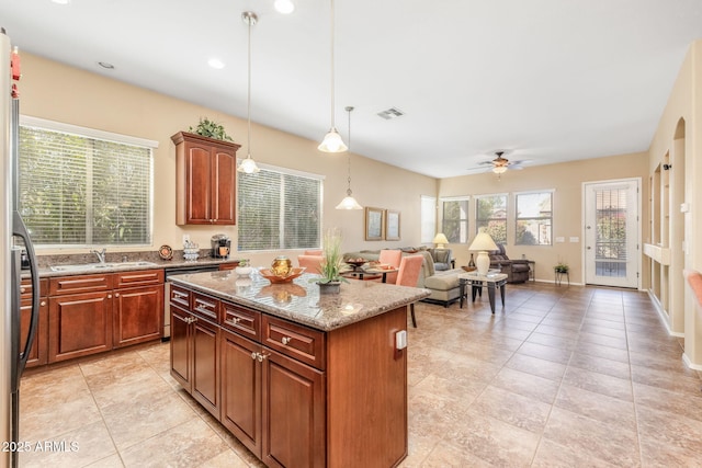 kitchen with sink, hanging light fixtures, a center island, stainless steel dishwasher, and light stone countertops