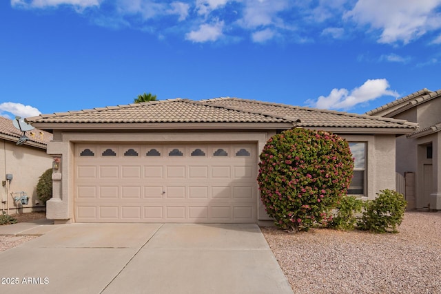 view of front of house featuring a tile roof, stucco siding, an attached garage, and concrete driveway