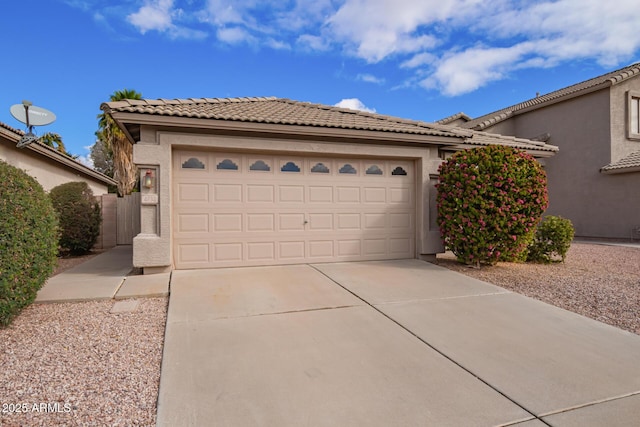 view of front facade with stucco siding, driveway, a tile roof, and a garage