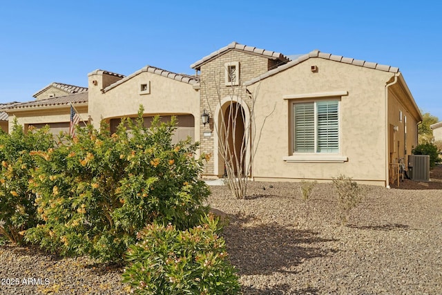 mediterranean / spanish-style home featuring central AC and a garage