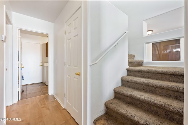 stairway with washer / dryer and wood finished floors