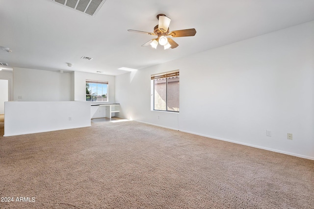 spare room featuring carpet, visible vents, and baseboards