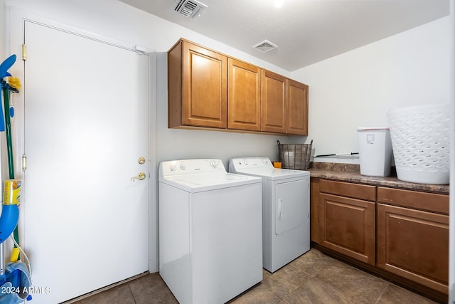 washroom with cabinet space, washing machine and clothes dryer, and visible vents