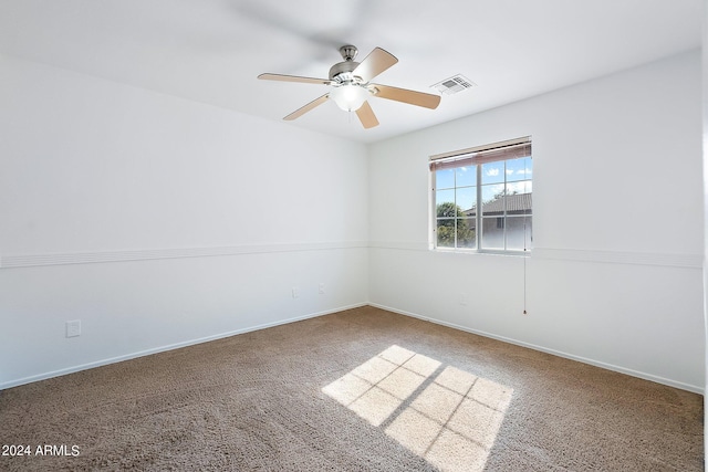 carpeted spare room featuring baseboards, visible vents, and a ceiling fan