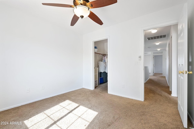 unfurnished bedroom with ceiling fan, carpet floors, visible vents, baseboards, and a spacious closet